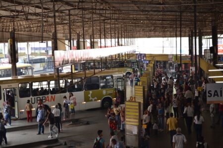 foto do terminal urbano de anápolis, mostrando ônibus parados e cidadãos transitando pelo espaço.